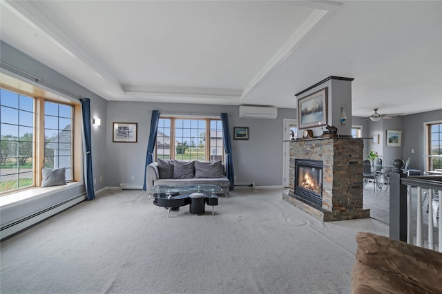 carpeted living room featuring a fireplace, a raised ceiling, a baseboard heating unit, an AC wall unit, and baseboards