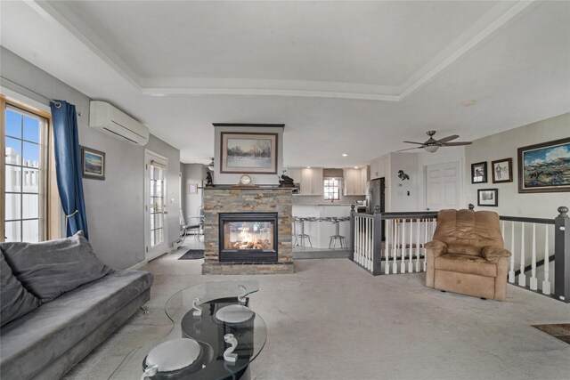 living room with light carpet, a wall mounted AC, a fireplace, and a raised ceiling