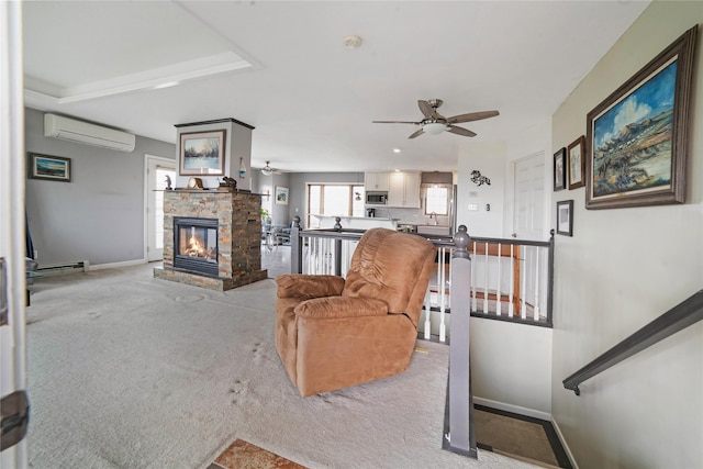 living area featuring baseboard heating, light colored carpet, baseboards, and a wall mounted AC