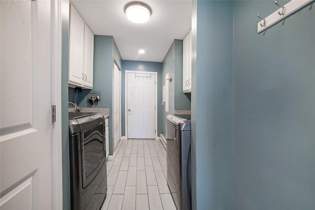 laundry room with washing machine and dryer, cabinet space, baseboards, and wood tiled floor