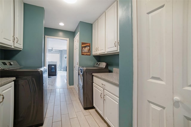 washroom with washer and dryer, cabinet space, a fireplace, and recessed lighting