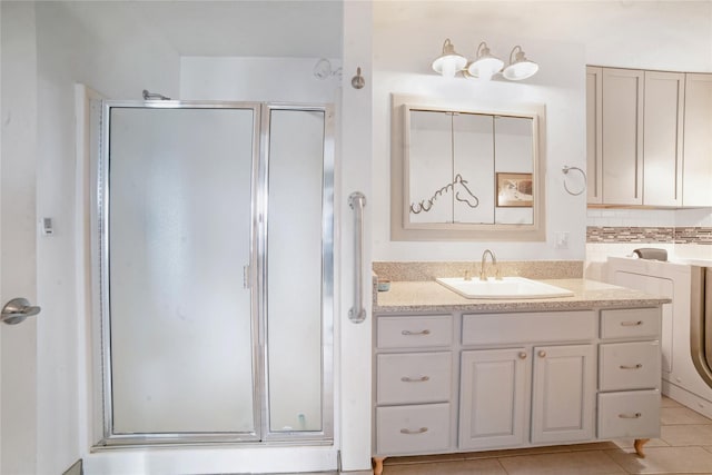 full bath featuring a shower stall, vanity, decorative backsplash, and tile patterned floors