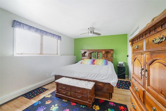 bedroom with a ceiling fan, light wood-type flooring, baseboards, and baseboard heating