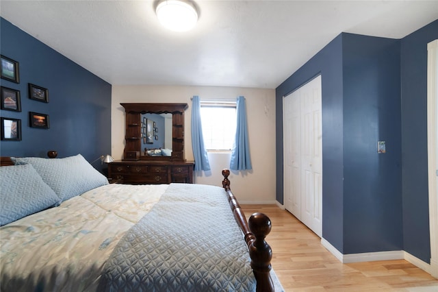 bedroom featuring light wood-style floors, a closet, and baseboards