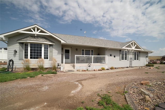 view of front of property featuring a shingled roof and covered porch