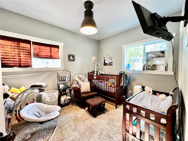 carpeted bedroom with a nursery area