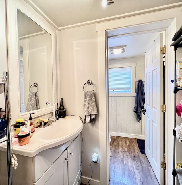 bathroom featuring wood-type flooring, vanity, and wood walls