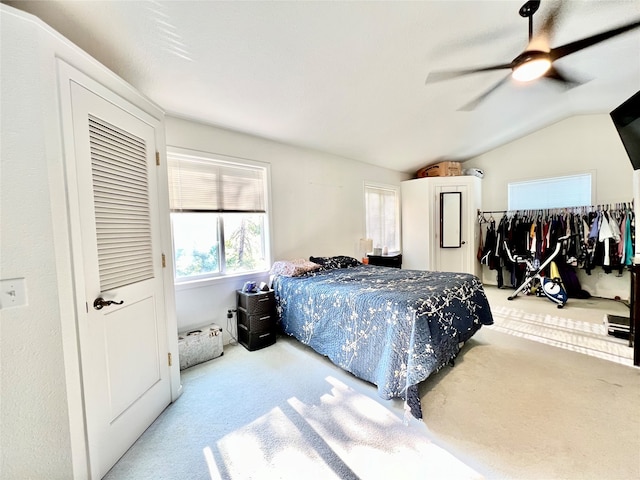 carpeted bedroom with ceiling fan and vaulted ceiling