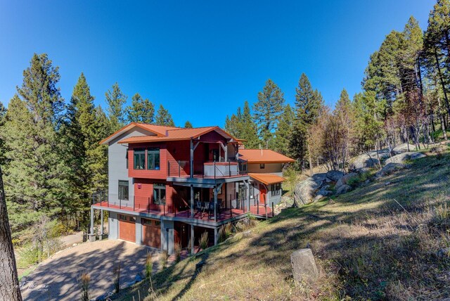 rear view of property featuring a balcony and a yard