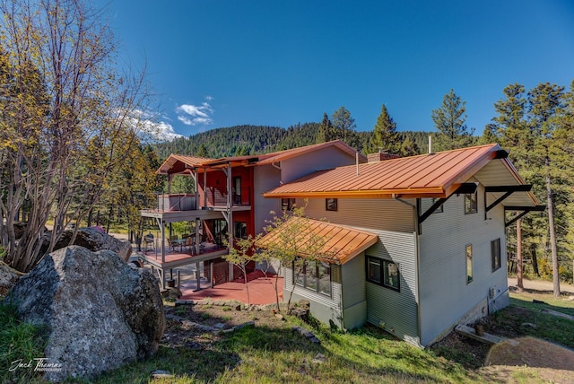 rear view of house with a patio area and a balcony