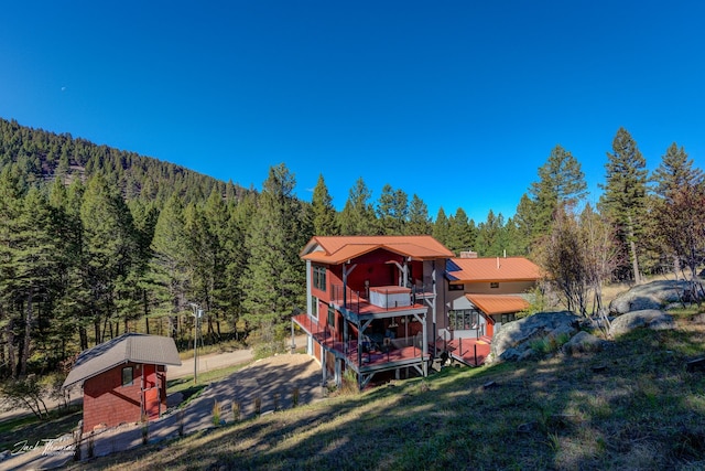 back of property featuring a yard and a wooden deck