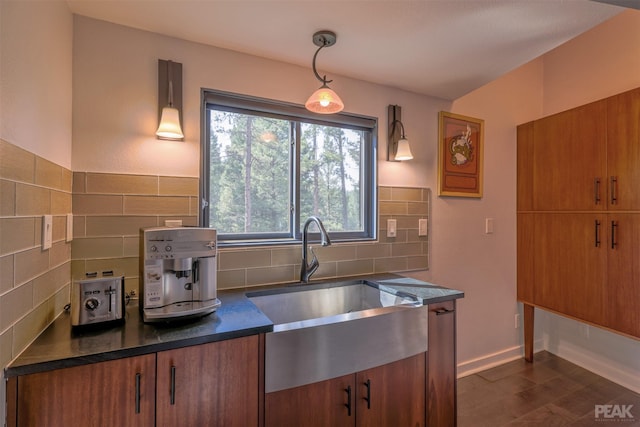 kitchen with decorative backsplash, dark hardwood / wood-style floors, hanging light fixtures, and sink