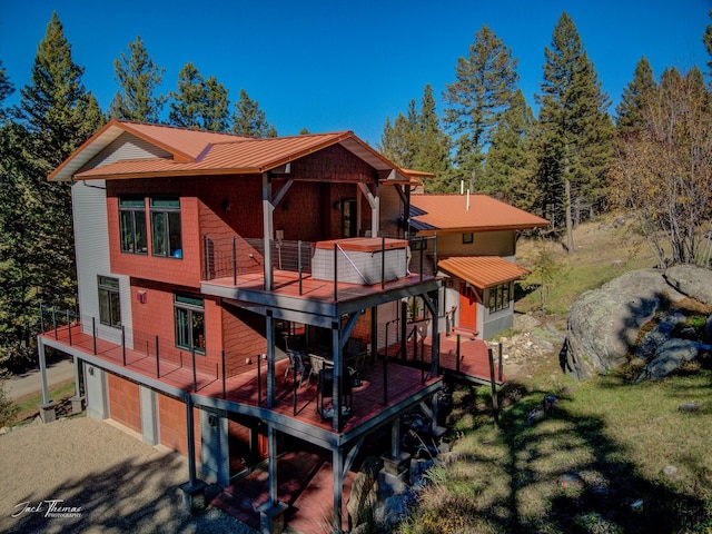 rear view of house featuring a garage, a balcony, and a yard