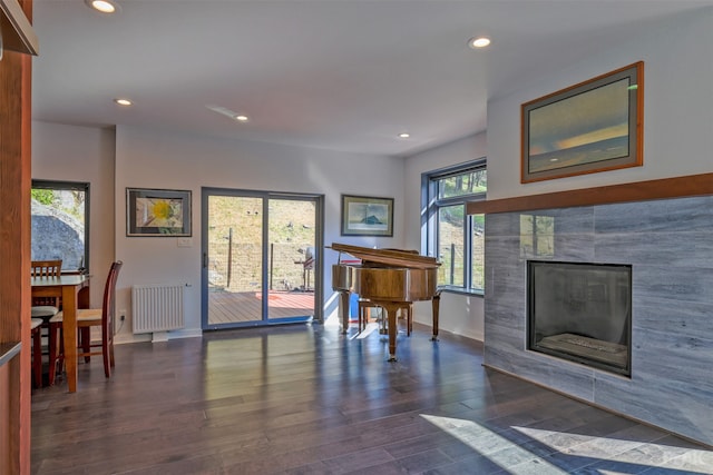 interior space featuring radiator, a tiled fireplace, and dark hardwood / wood-style floors