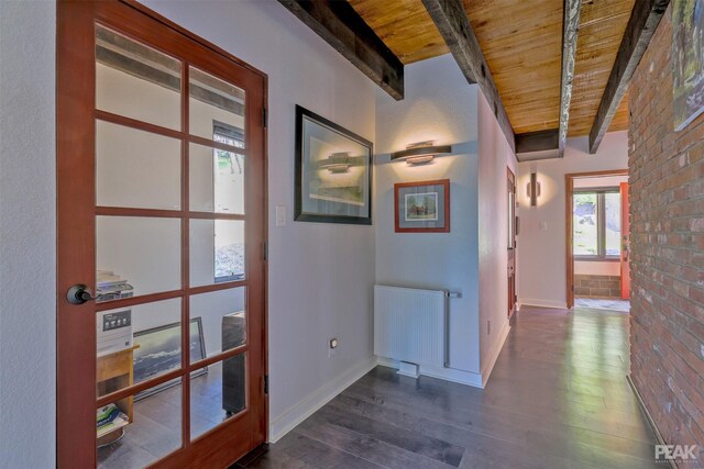 hall featuring beam ceiling, radiator heating unit, wood ceiling, brick wall, and hardwood / wood-style floors