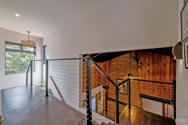 staircase featuring wood walls, hardwood / wood-style floors, and ceiling fan