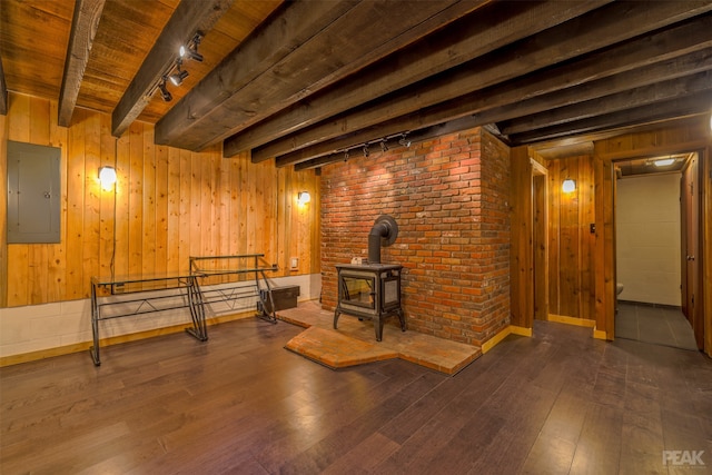 basement featuring a wood stove, wood-type flooring, and electric panel