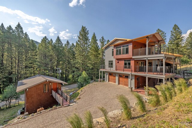 back of house with a balcony and a garage