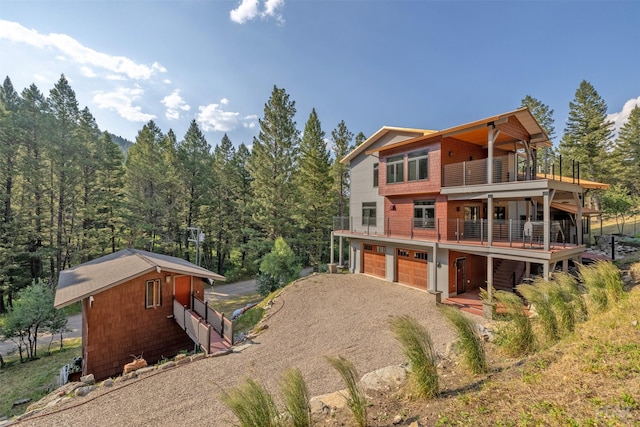 back of property with a garage and a balcony