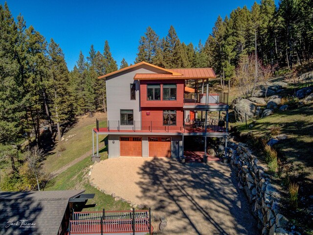 exterior space featuring a balcony, a garage, and a lawn