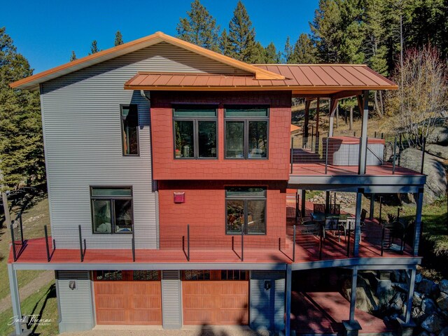 back of property featuring a garage and a wooden deck