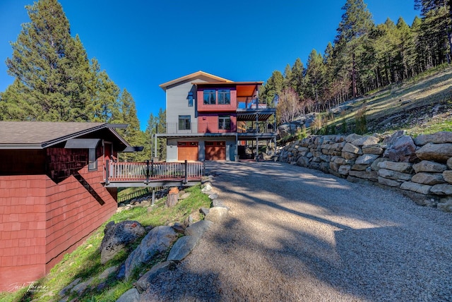 back of property with a wooden deck and a garage