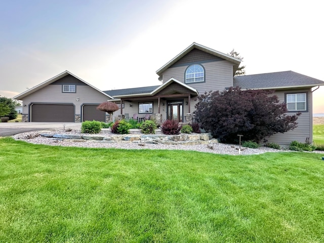 view of front of property with aphalt driveway, a front yard, and a garage
