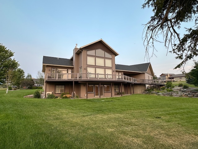 back of house featuring a lawn and a deck