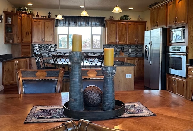 kitchen featuring decorative backsplash, pendant lighting, and stainless steel appliances