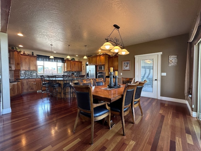 dining room with dark hardwood / wood-style flooring and a textured ceiling