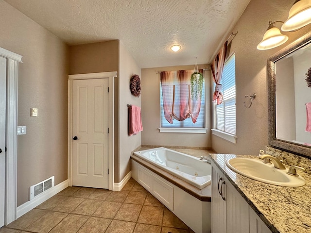 bathroom with a jetted tub, a textured ceiling, visible vents, tile patterned floors, and vanity
