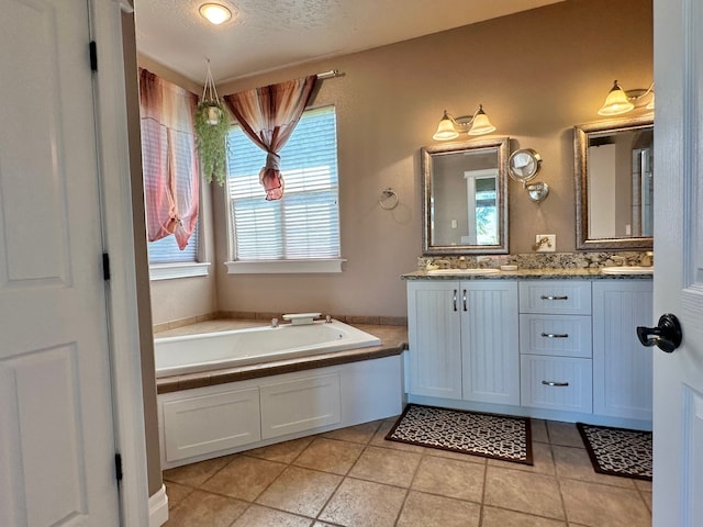 full bathroom with double vanity, tile patterned flooring, a garden tub, and a textured ceiling