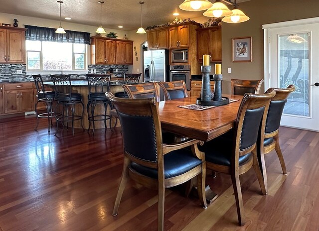 dining room featuring recessed lighting, dark wood finished floors, and a textured ceiling