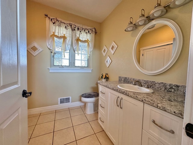 half bathroom with visible vents, tile patterned flooring, vanity, baseboards, and toilet