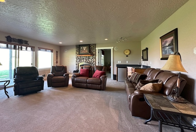 carpeted living room featuring a fireplace and a textured ceiling