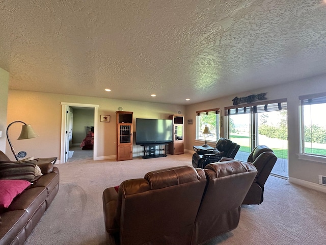 living room featuring recessed lighting, a textured ceiling, light colored carpet, and baseboards