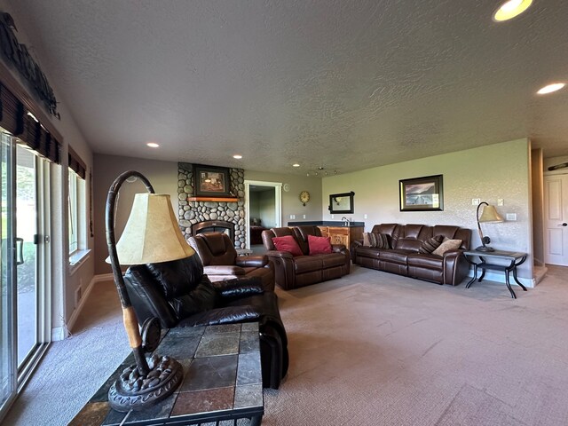 living area with carpet floors, recessed lighting, a textured ceiling, and a fireplace