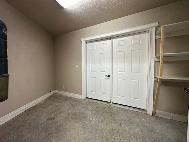 unfurnished bedroom with a closet, baseboards, and concrete flooring