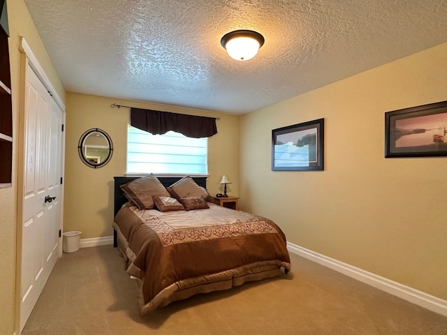 bedroom with carpet floors, a textured ceiling, baseboards, and a closet