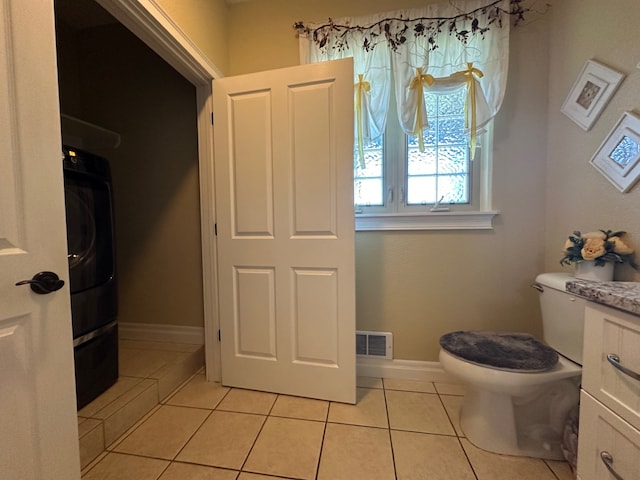 bathroom with tile patterned floors, vanity, toilet, and washer / clothes dryer