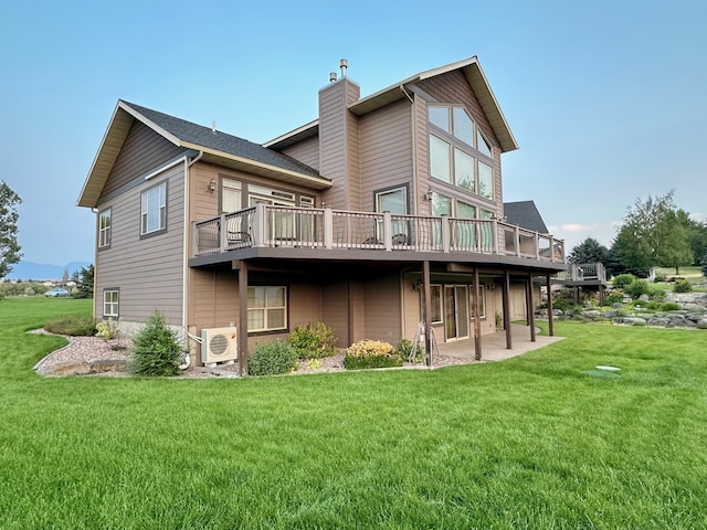 rear view of house featuring a deck, a chimney, a patio area, ac unit, and a yard