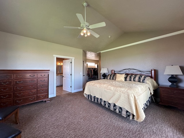 bedroom featuring ceiling fan, ensuite bathroom, vaulted ceiling, light carpet, and a closet