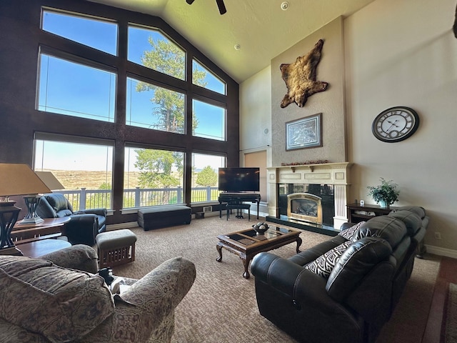 living room with carpet, a towering ceiling, a fireplace, and ceiling fan