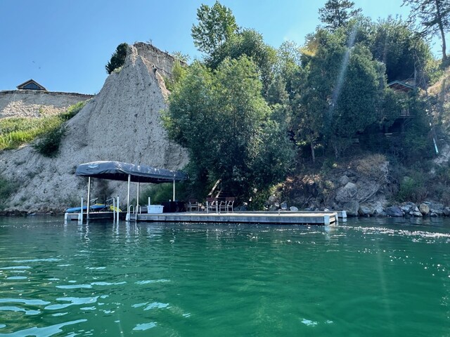 view of pool with a water view and a dock
