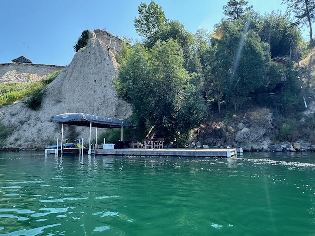 view of swimming pool with a water view and a dock