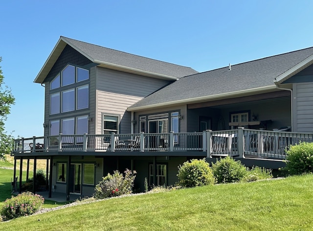 back of property featuring a lawn and a wooden deck