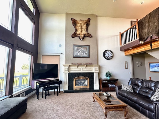 living room with carpet floors, a fireplace, and a high ceiling