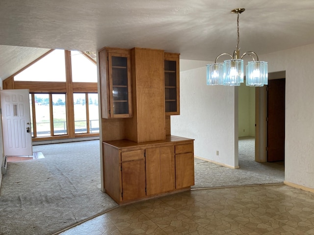 384 Eagle Ln, Corvallis, MT 59828 - kitchen featuring carpet floors, a chandelier, brown cabinetry, and glass insert cabinets