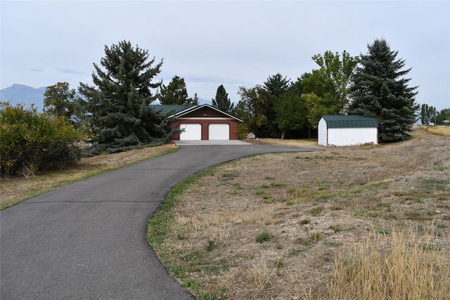 exterior space featuring a mountain view, an outdoor structure, and a garage