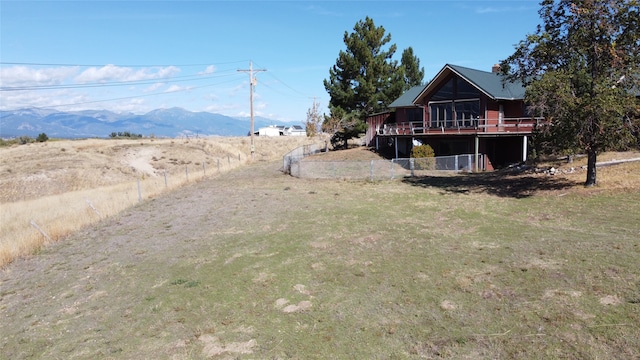 view of yard featuring a rural view and a deck with mountain view